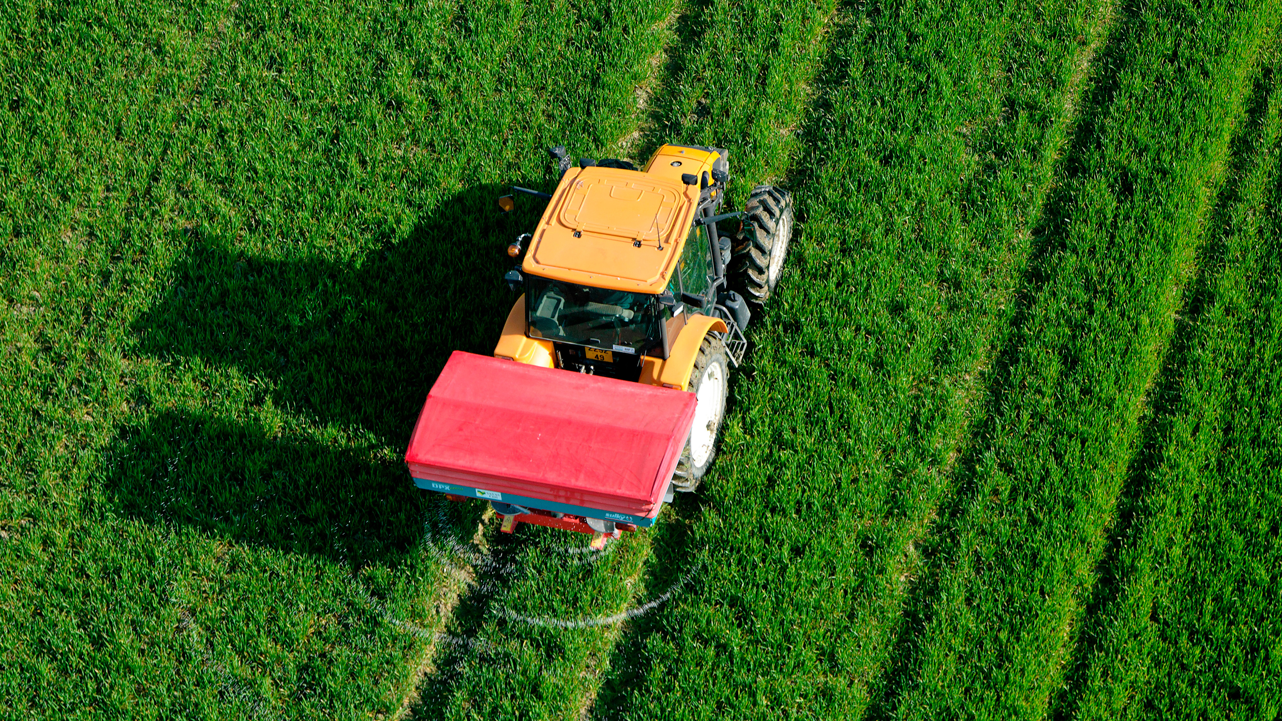 Bird's eye view of tractor with fertilizer spreader (16:9)
